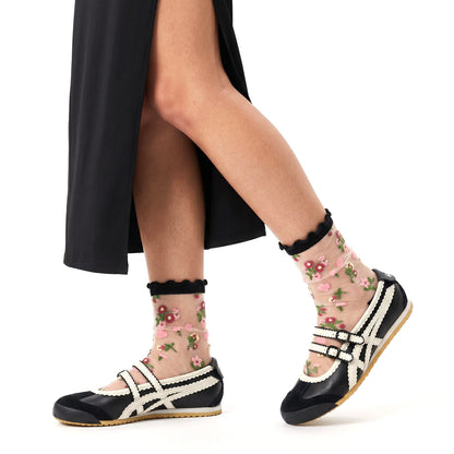 Floral sheer socks worn with black and white shoes on a white background