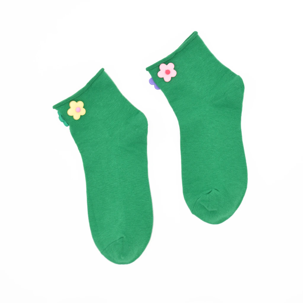 Pair of green socks with flower decorations on a white background