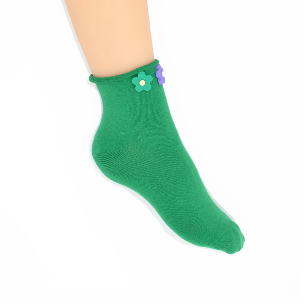 Green sock with a flower design on a white background