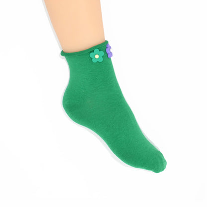Green sock with a flower design on a white background