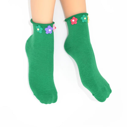 Green socks with colorful flower designs on a white background