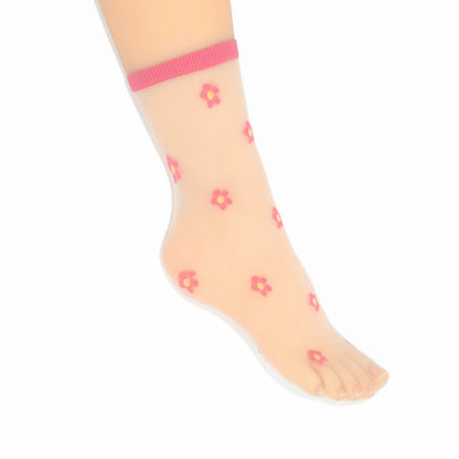 A leg modelling the Isla sheer daisy ankle socks in fuchsia pink on cream mesh base