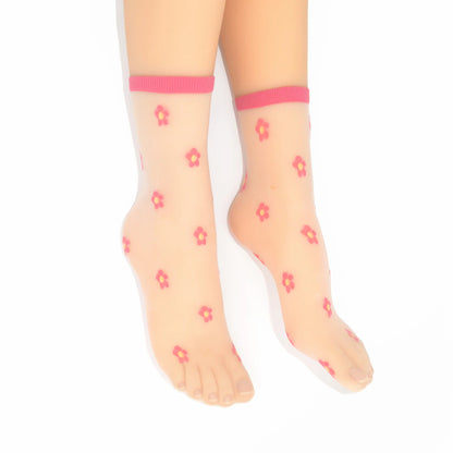 Legs modelling the Isla sheer daisy ankle socks in fuchsia pink on cream mesh base