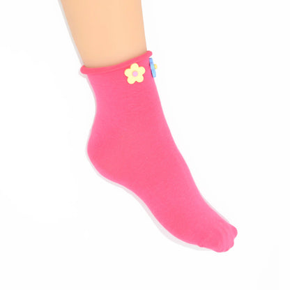 Pink sock with a yellow flower design on a white background