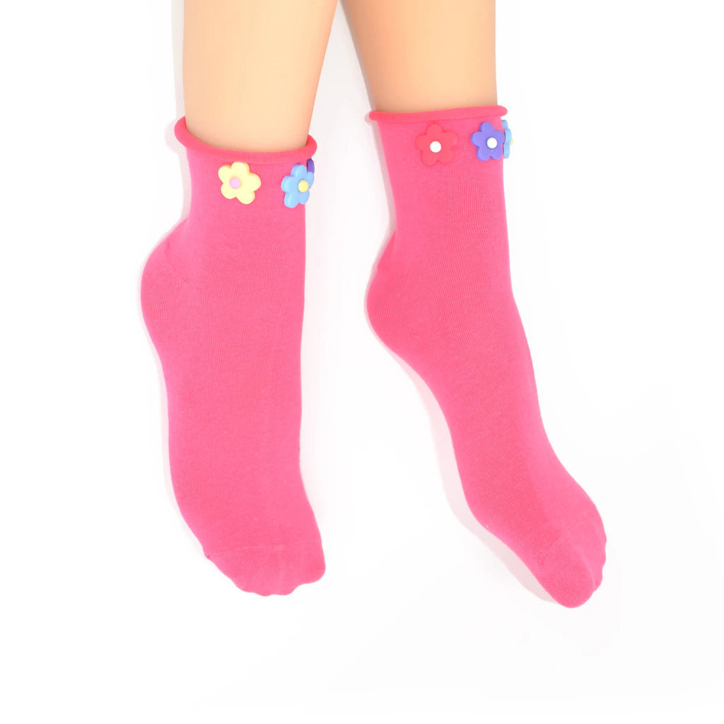Pink socks with colorful flower designs on a white background