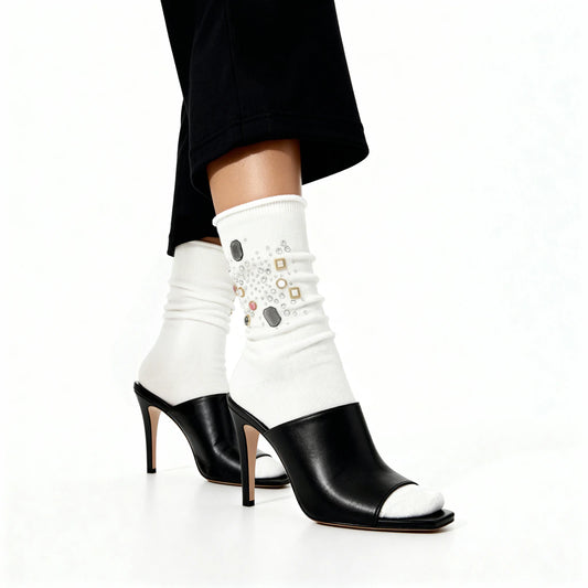 Black high-heeled shoes with white socks featuring decorative elements on a white background
