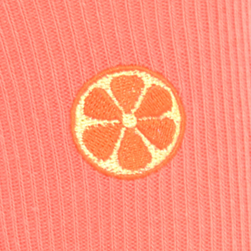 Embroidered grapefruit motif on a coral fabric background