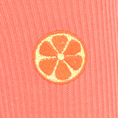 Embroidered grapefruit motif on a coral fabric background