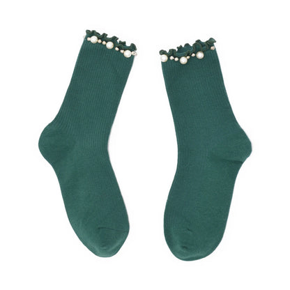 Pair of green socks with pearl details on a white background
