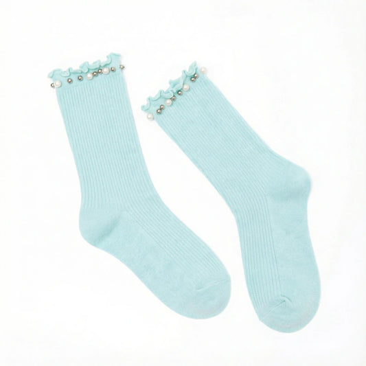 Pair of light blue socks with pearl embellishment on a white background