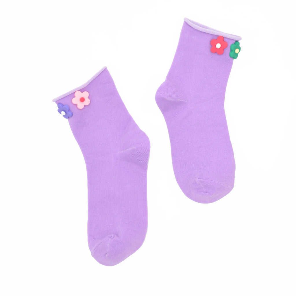 Pair of purple socks with flower decorations on a white background
