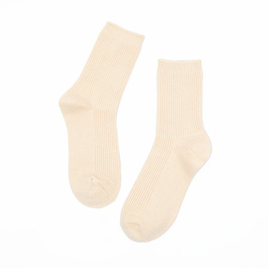 A pair of ribbed crew socks in a warm cream or off-white color, displayed against a solid white background.