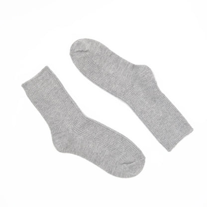 A pair of light gray ribbed crew socks laid flat on a solid white background.