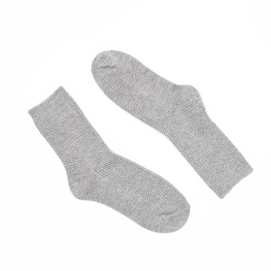 A pair of light gray ribbed crew socks laid flat on a solid white background.