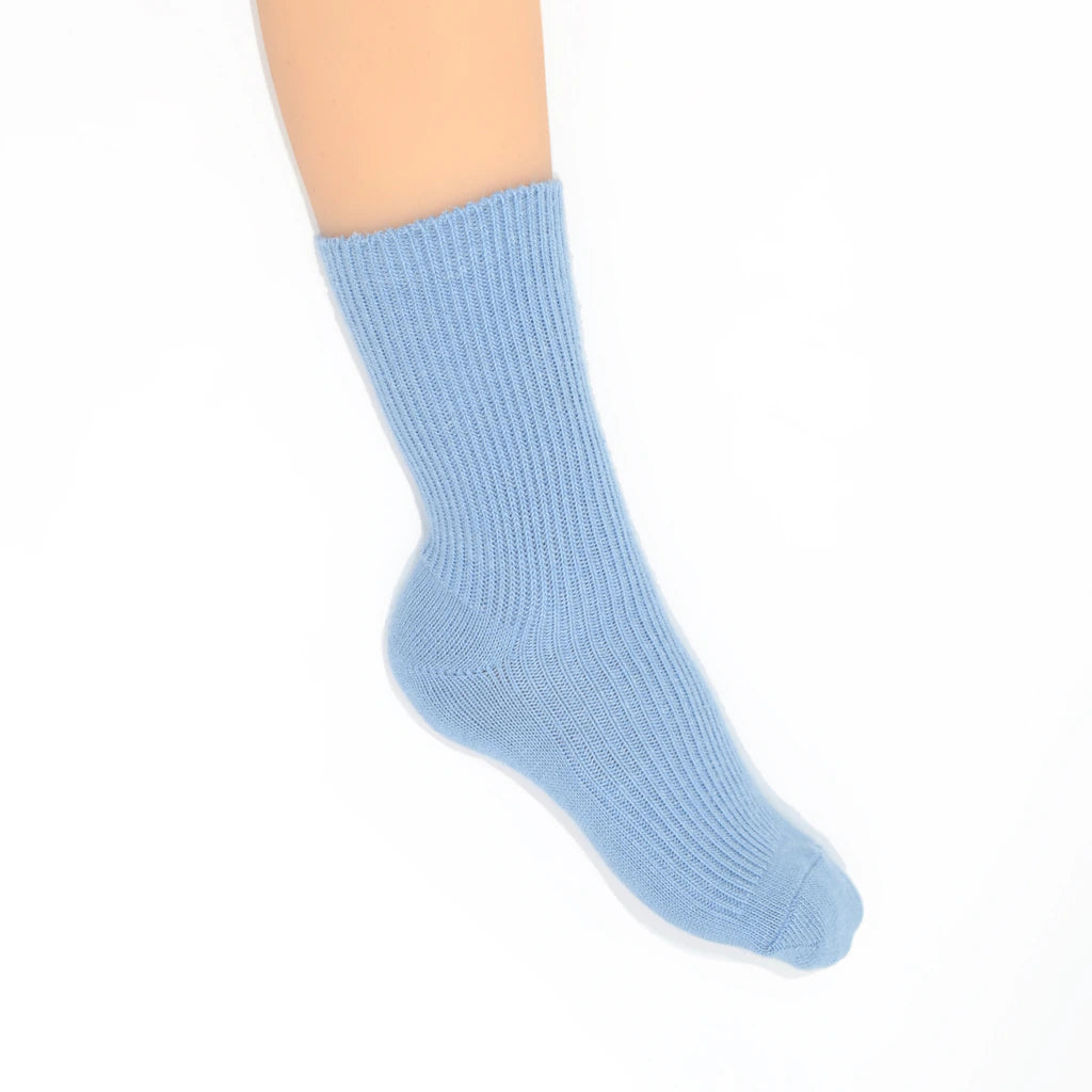 A light blue ribbed ankle sock shown on a  foot against a plain white background.