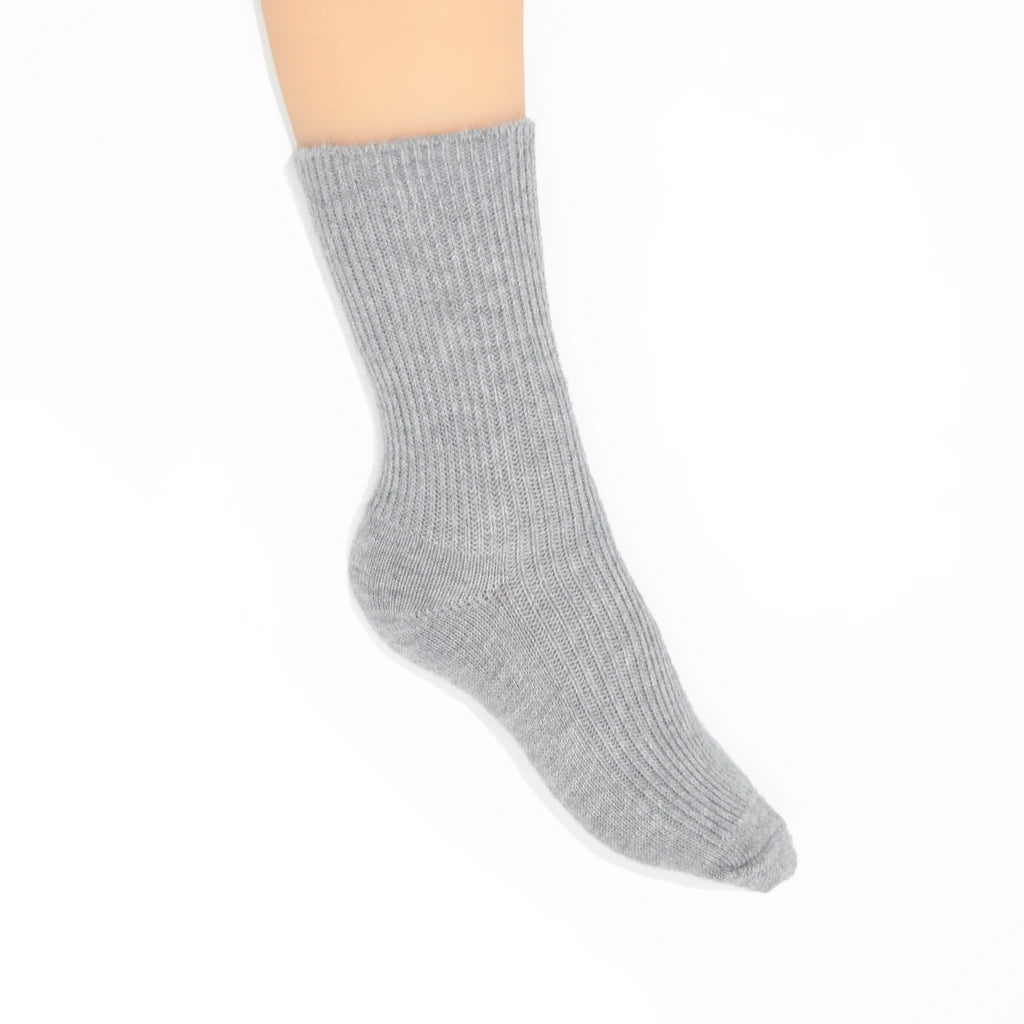 A light gray ribbed crew sock displayed on a  foot against a plain white background.