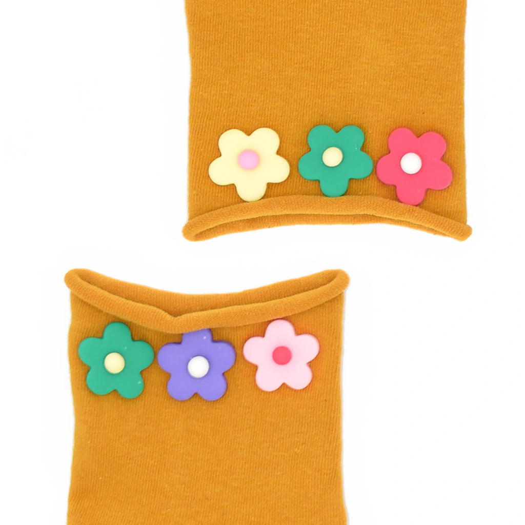 Two mustard yellow socks with colorful flower decorations on a white background