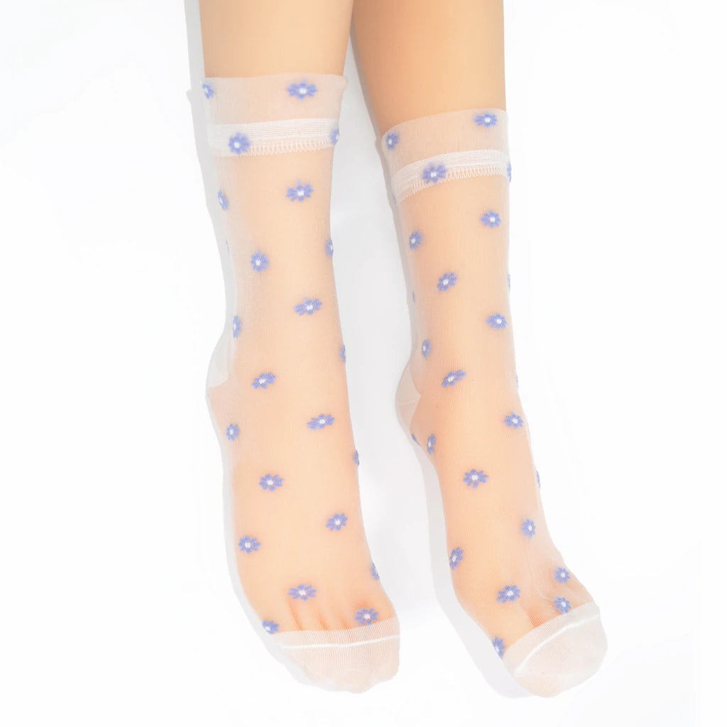 A pair of sheer white ankle socks with a small blue and white floral pattern, shown on a leg against a white background.