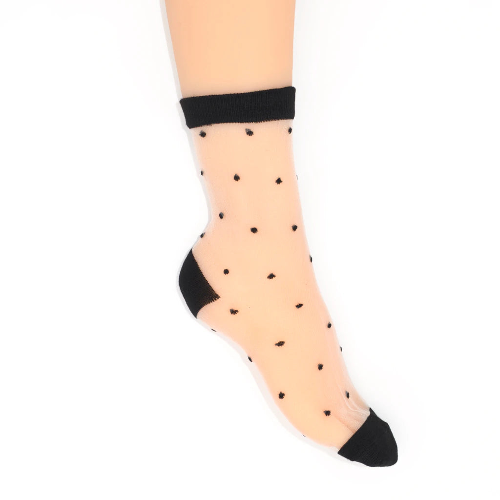 A single sheer sock with black polka dots, a black cuff, and a black toe, shown on a model's foot against a white background.