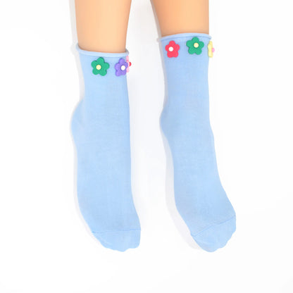 Light blue socks with colorful flower designs on a white background