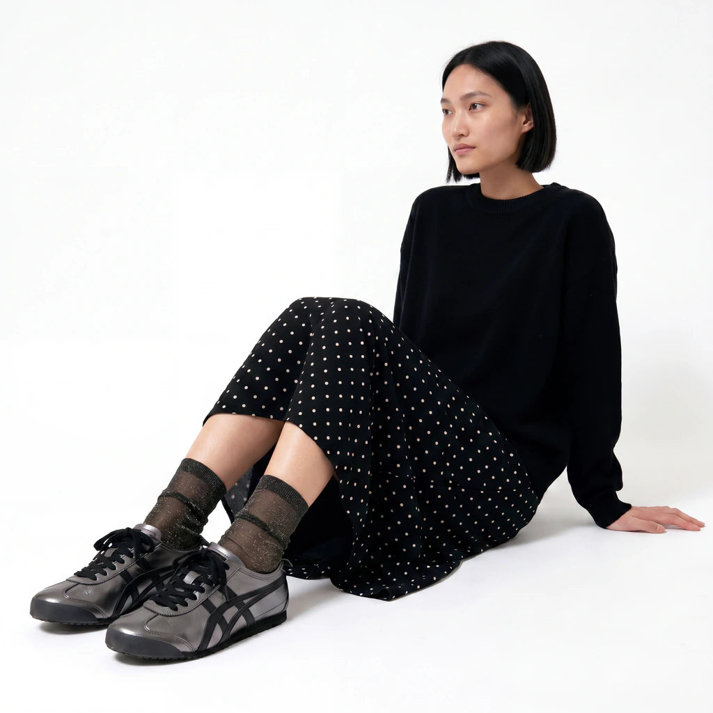 Model wearing Tiffany Black Diamond sheer sparkle socks with black trainers and a black polka dot skirt.