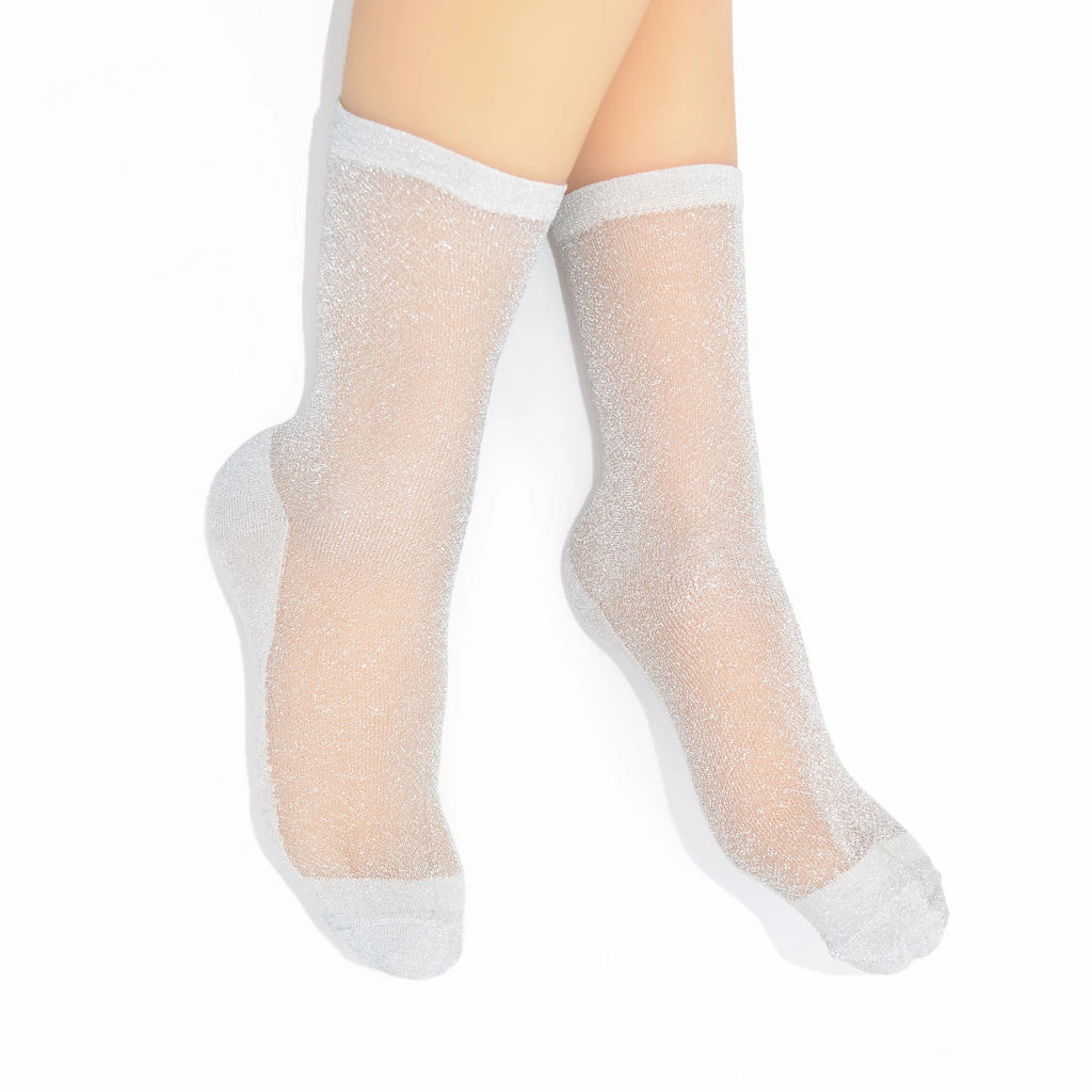 Sheer silver socks worn  on a white background