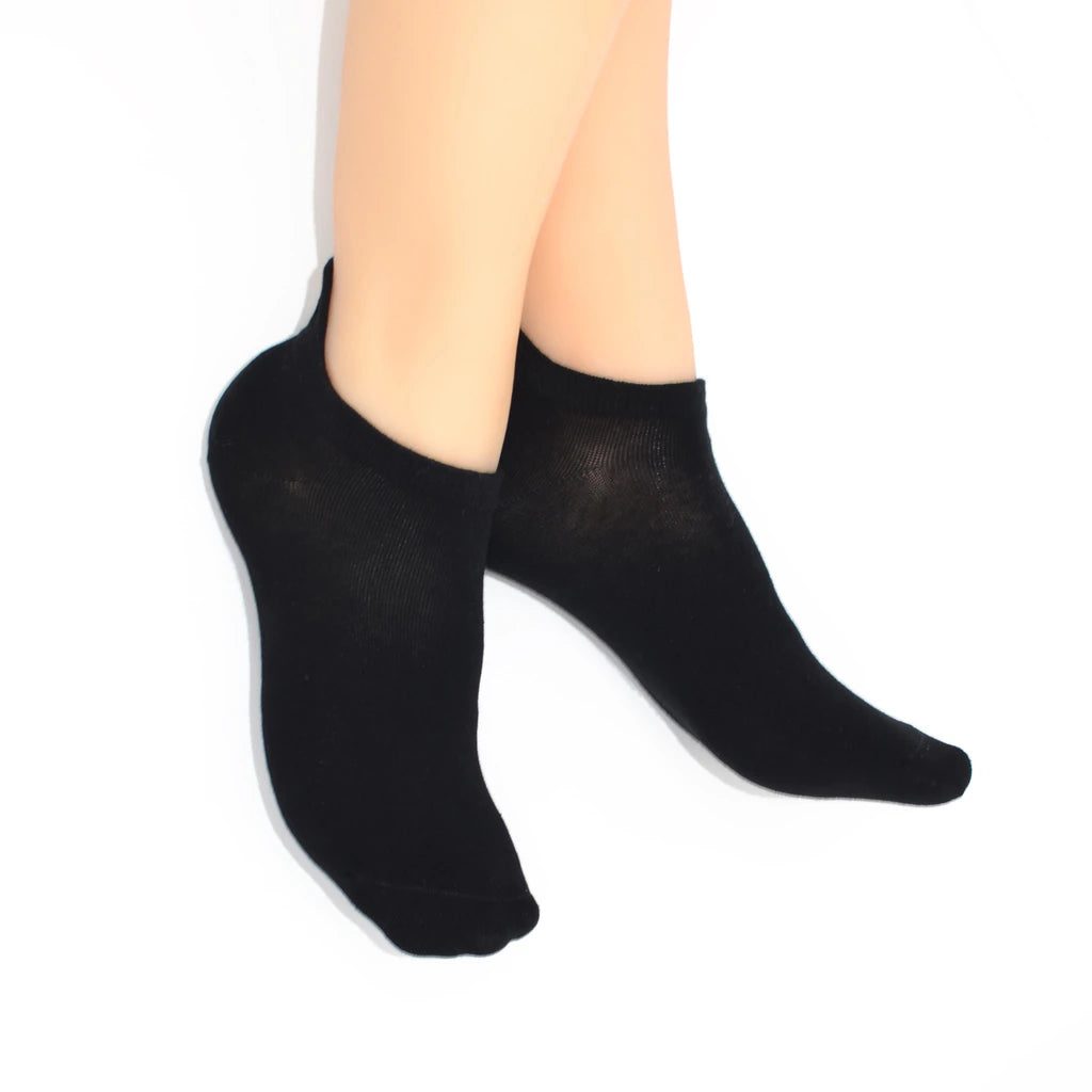 Legs modelling black no show socks with diamond-shaped embroidered tabs at the heel.