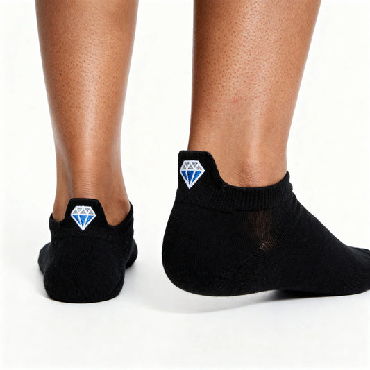 Black socks with blue diamond motif worn by a person on a white background