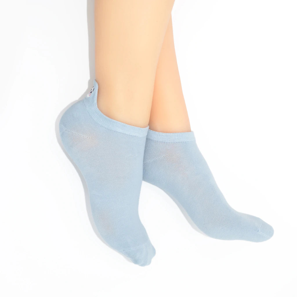 Legs modelling sky blue no show socks with an embroidered panda heel tab.