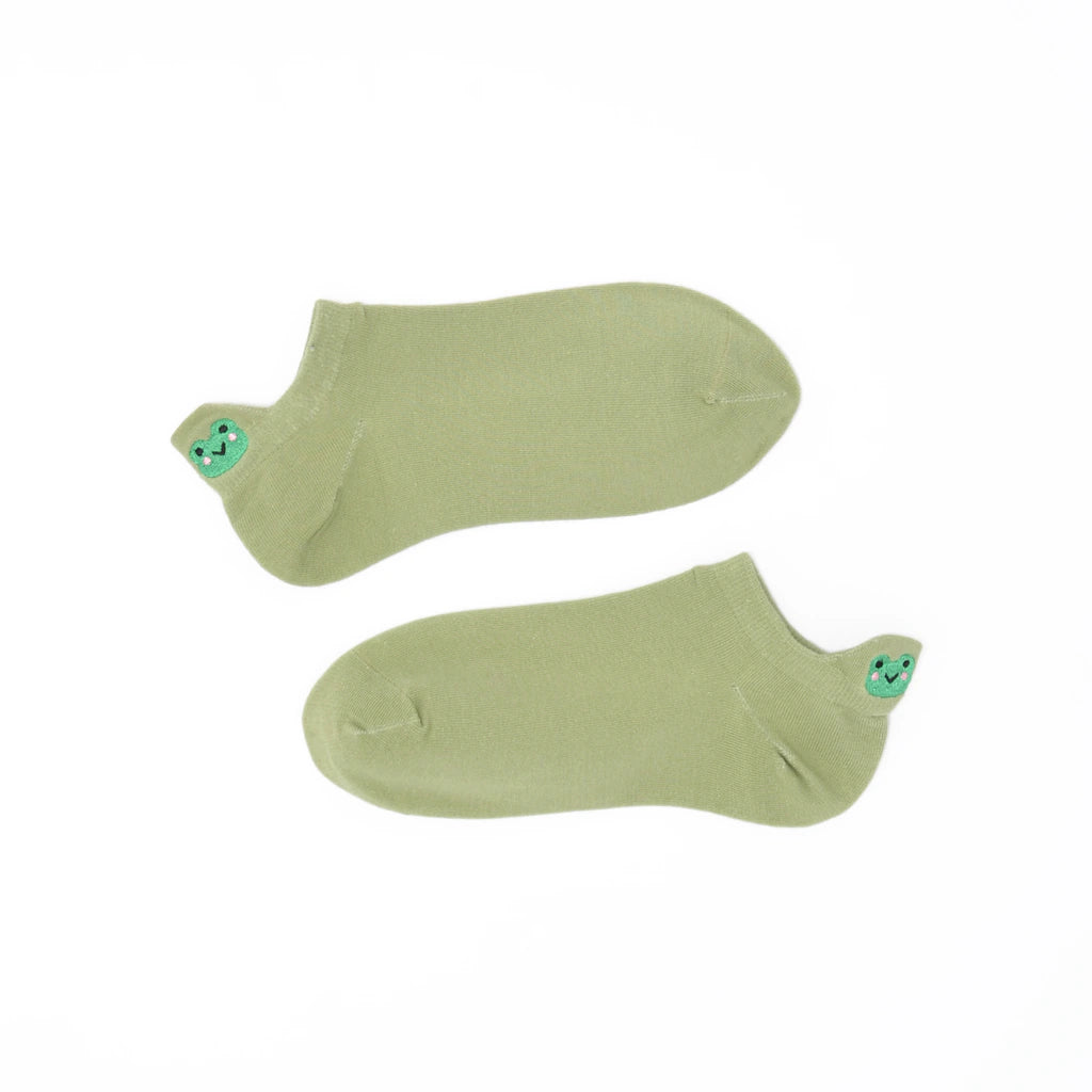 A pair of sage green no-show socks with an embroidered frog heel tab.