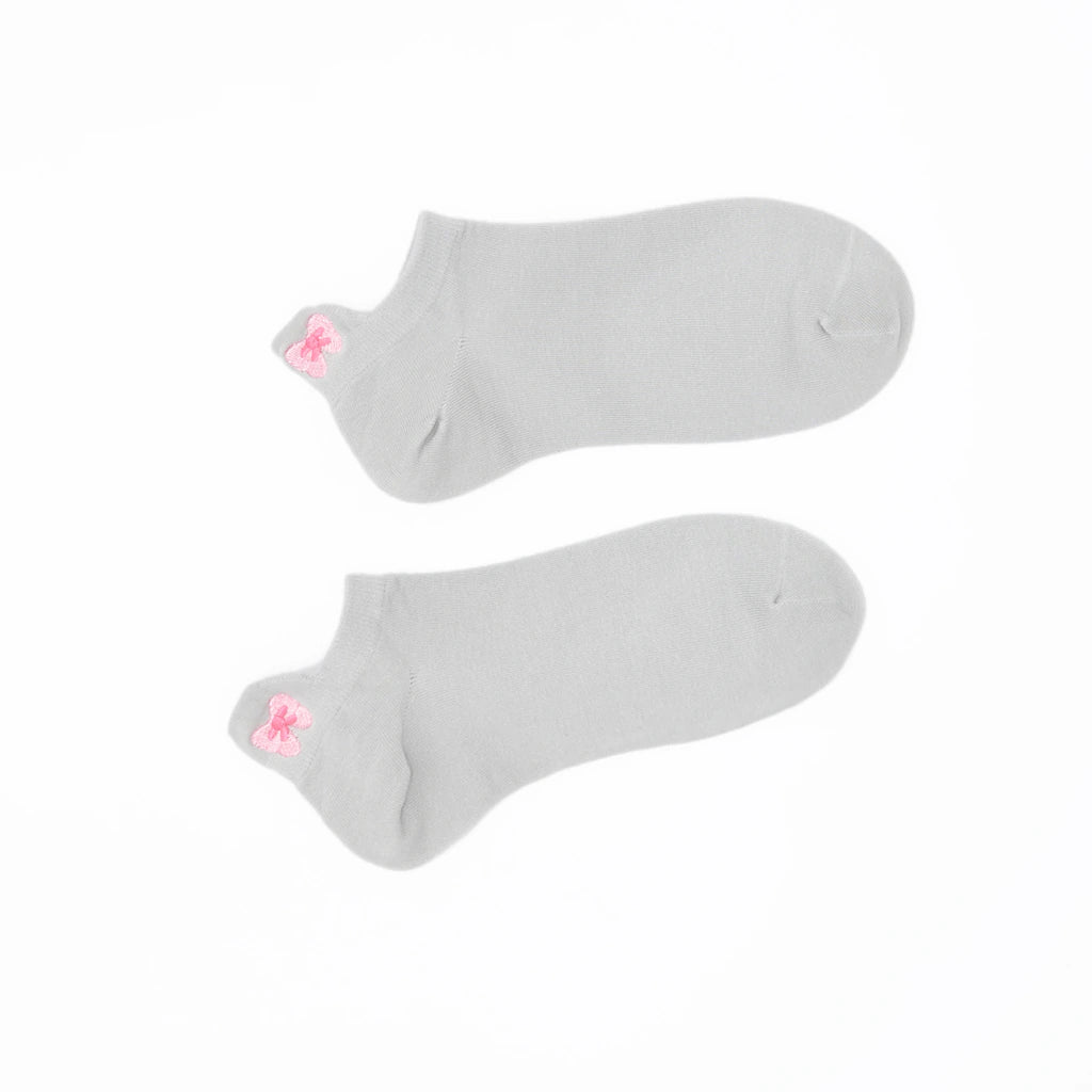 A pair of gray no-show socks with a embroidered tab at the heel in pink color.