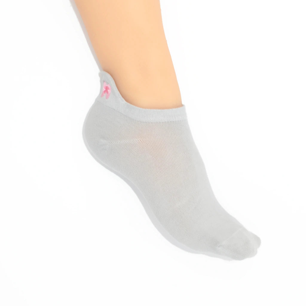 Leg modeling a  gray no-show sock with a embroidered tab at the heel in pink color.