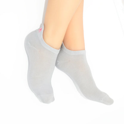 Legs modeling a  gray no-show socks with a embroidered tab at the heel in pink color.