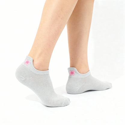 Gray ankle socks with a pink bow worn by a person on a white background