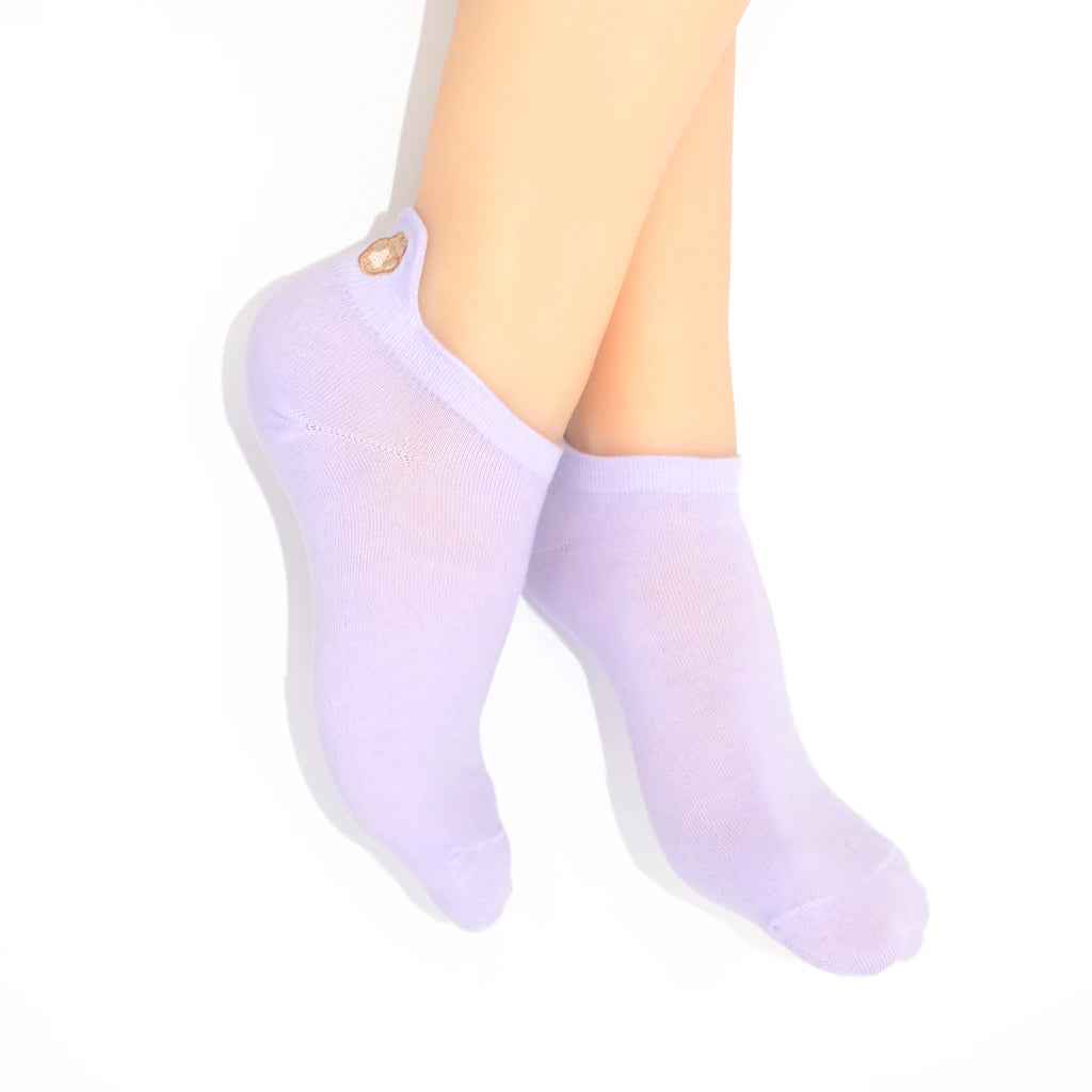 Legs modelling purple no-show socks with an embroidered paw print tab on the heel.