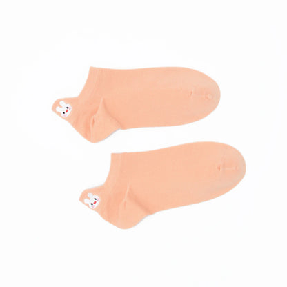 A pair of peach-colored no-show socks with an embroidered bunny heel tab design.