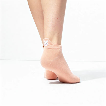 Pink ankle sock with a small white bunny design on a white background