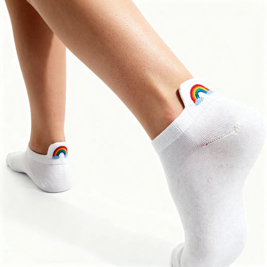 White socks with rainbow designs worn by a person on a white background