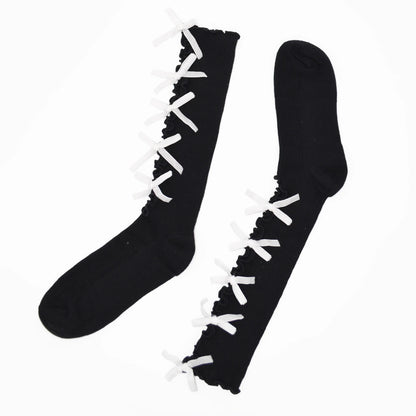 A pair of black knee-high socks with white lace-up detailing running up the front, displayed on a clean white background.