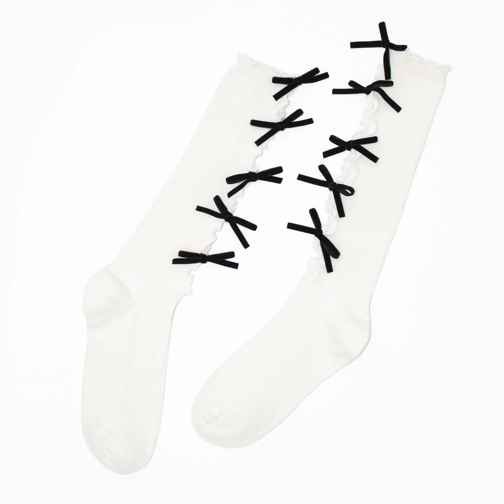 A pair of white thigh-high socks with black lace-up bow details running up the front, displayed on a clean white background.