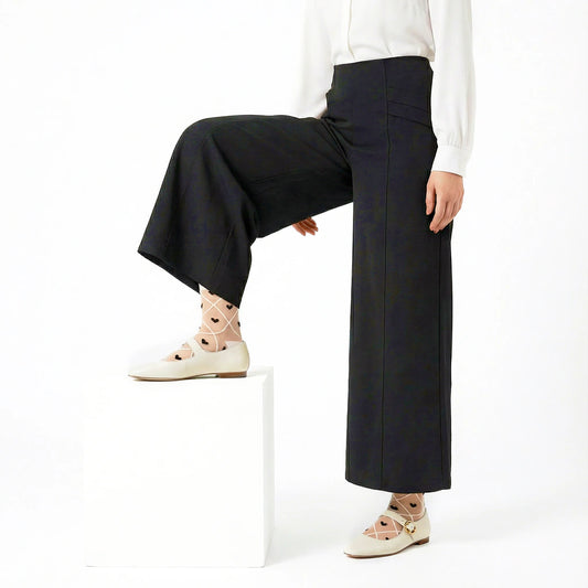 model posing wearing wide leg pants and sheer criss cross heart socks and cream leather mary janes