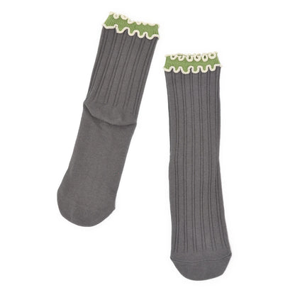 Pair of gray socks with green trim on a white background