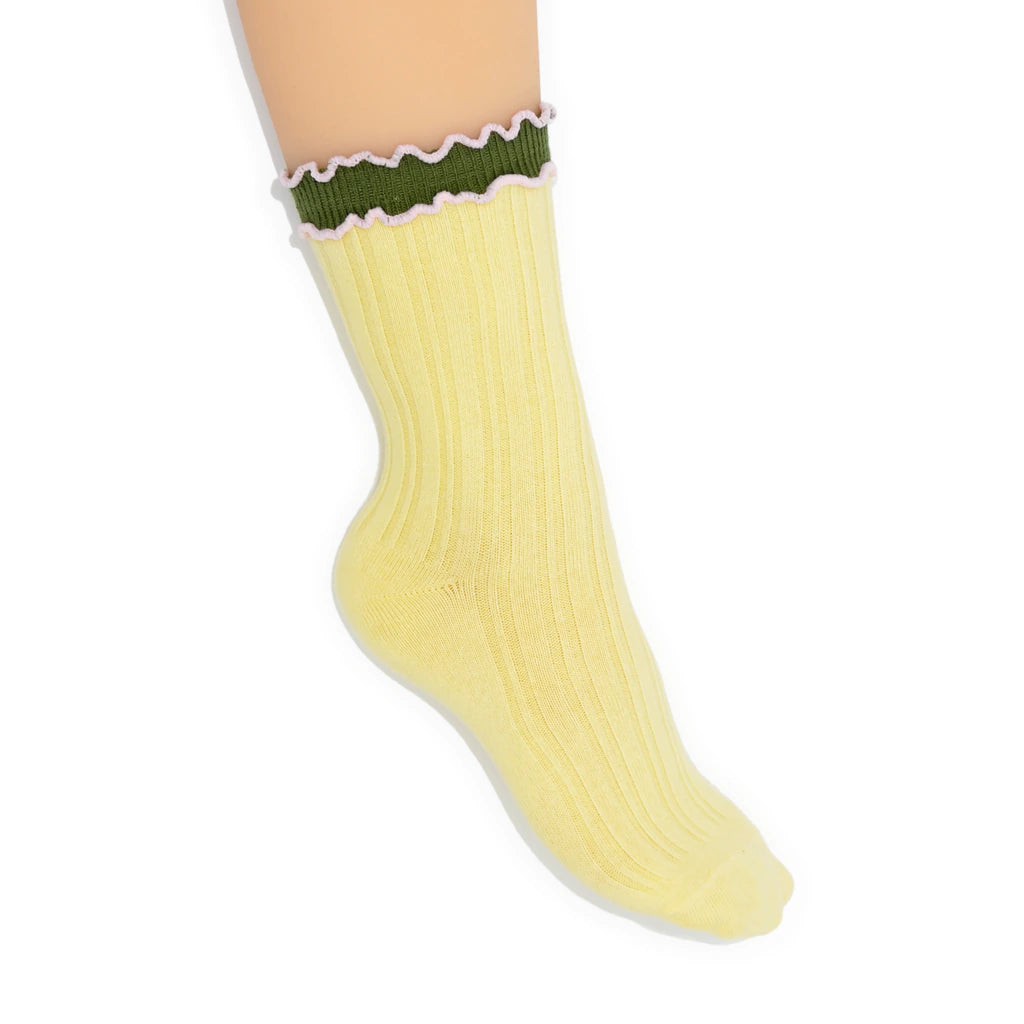 Yellow sock with green top on a white background
