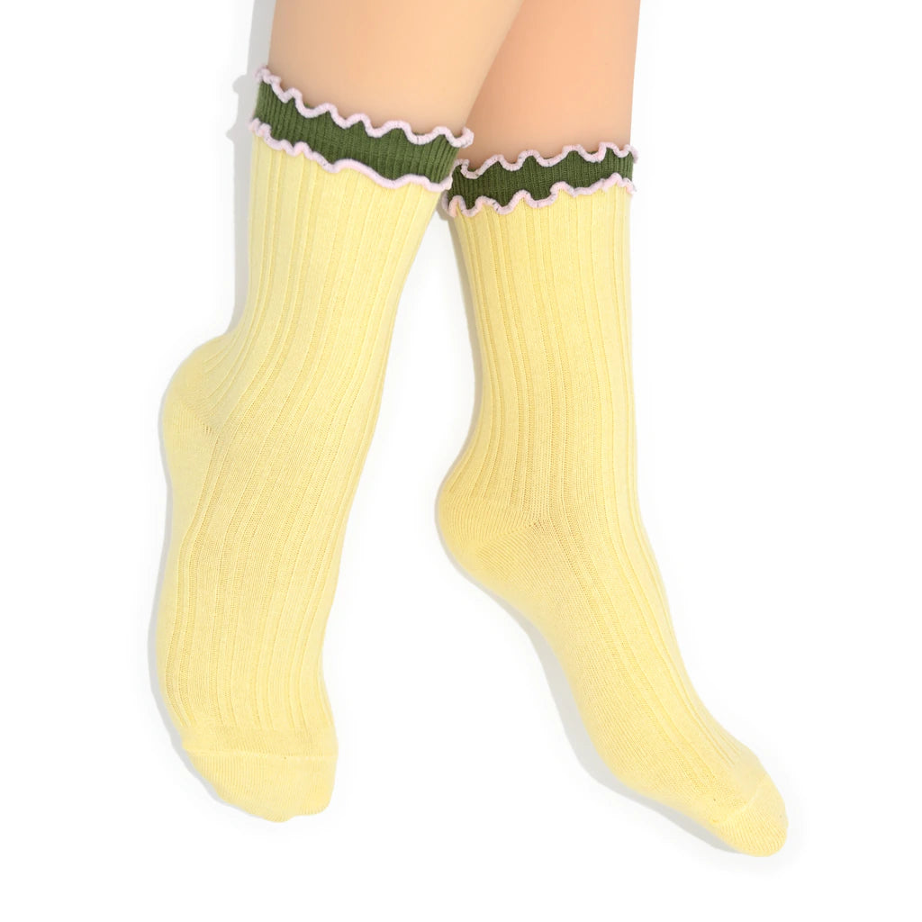 Yellow crew socks with green and white trim on a white background