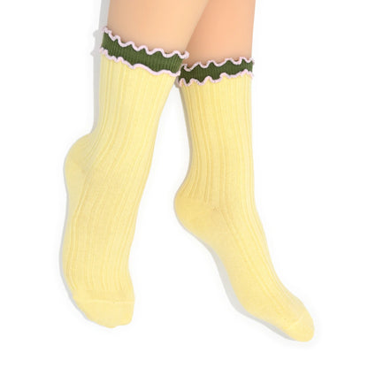 Yellow crew socks with green and white trim on a white background