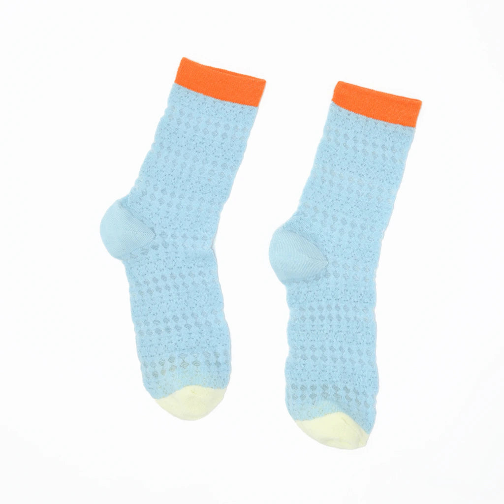 Pair of light blue socks with orange cuffs on a white background