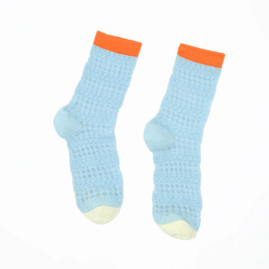 Pair of light blue socks with orange cuffs on a white background