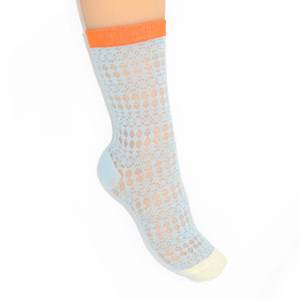 A leg modelling light blue socks with orange cuffs on a white background