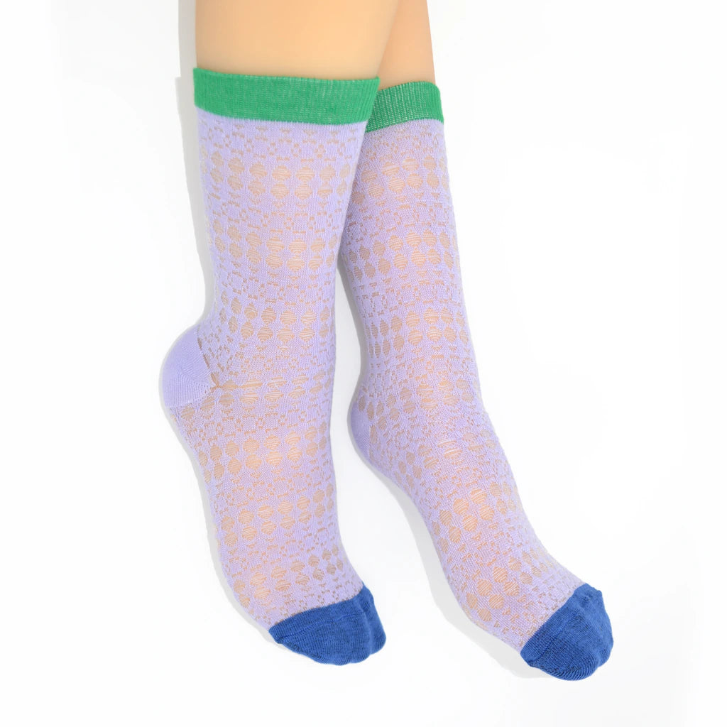 Legs modelling light purple socks with green cuffs and blue toes on a white background