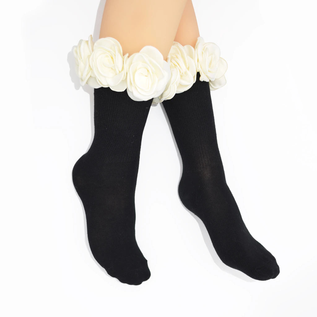 Black crew socks with a wide white fabric rose cuff, shown on a model's legs against a white background.